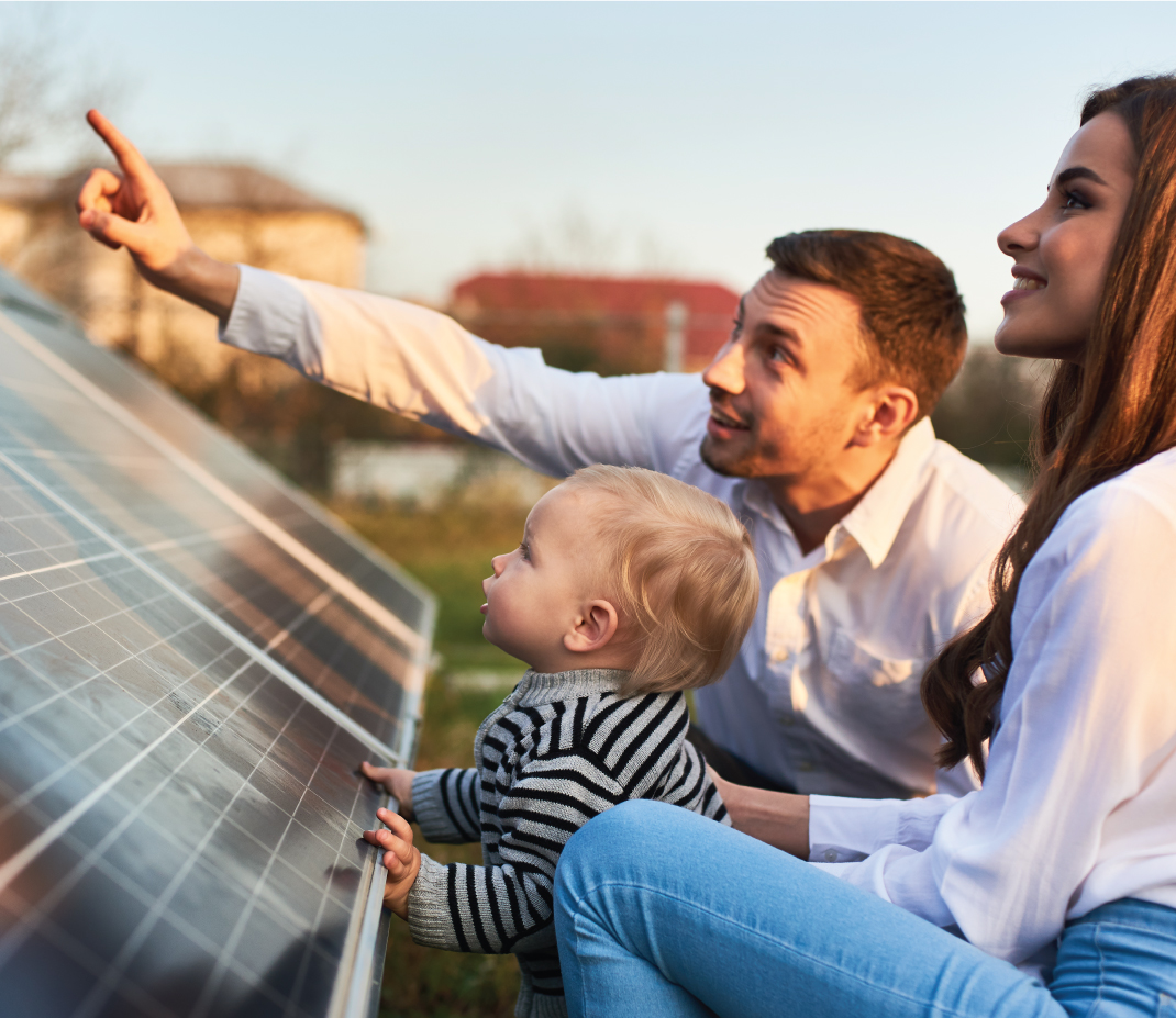 Mother and father showing toddler their home's solar panel.